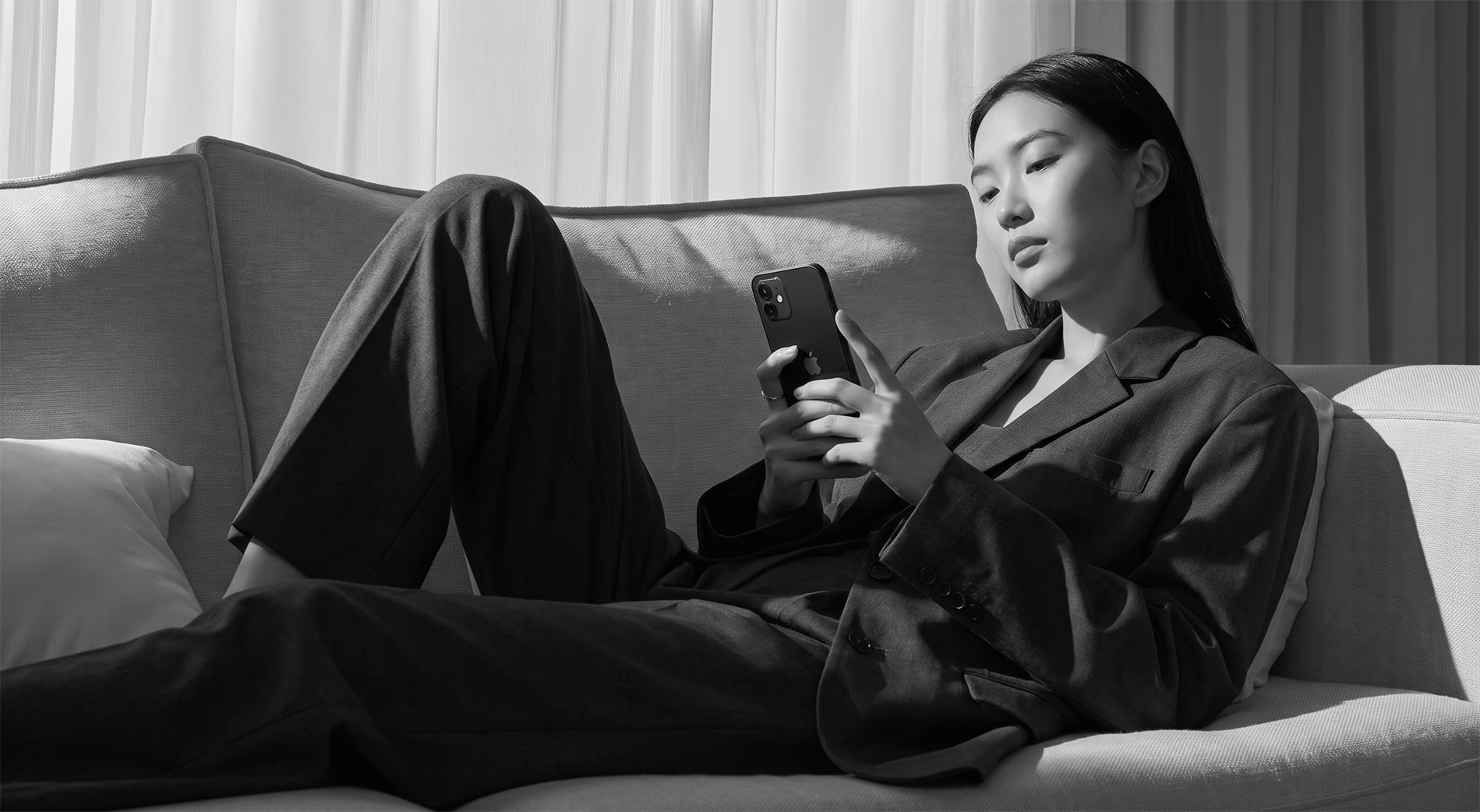 Woman using a smartphone on a sofa
